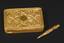 Golden rectangular snuffbox with a hinged lid and a snuff spoon in the Egyptian Queen torso shape.