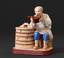 An old peasant drinking water from a bucket: A porcelain figure with a cassette