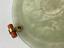 ART DECO ROUND JADE, GOLD, CABOCHON EMERALD AND CORAL SAUCER AND ONE MALACHITE MARQUETRY JADE, CORAL, GOLD AND CABOCHON ONYX CUP, CIRCA 1925