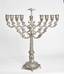 Hanukkah lamps were often decorated in the form of famous Jewish symbols: the temple menorah, the star of David, lions, an eagle, a cherub, a crown, etc.sometimes the coats of arms of aristocratic families served as decorations for Hanukkah lamps.
A Russian sterling silver Hanukkah lamp with detachable oil jug decorated with floral pattern in the form of rose buds on the candlesticks and base.
First half of XX century