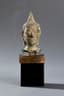 SMALL BUDDHA HEAD WITH CLOSED EYES AND CURLY HEADDRESS SURMOUNTED BY THE FLAMMED USHNISHA
THAILAND, 16TH - 17TH CENTURY